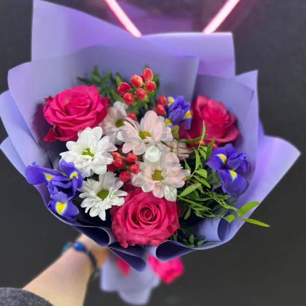 Букет из малиновых роз, синих ирисов и хризантем с добавлением гиперикума в лавандовом оформлении