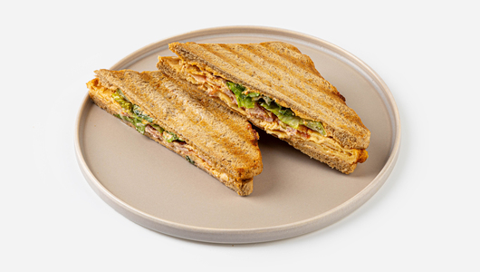 Сэндвич с беконом и скрэмблом на хлебе с отрубями, кафе