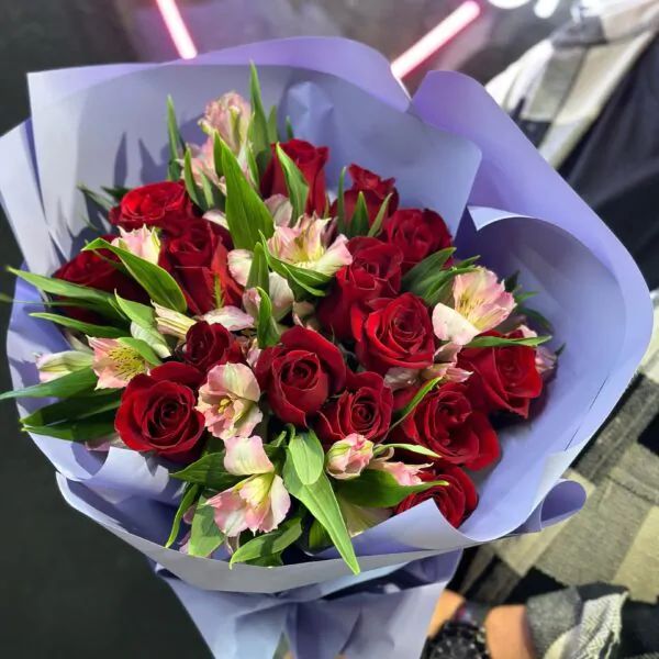 Букет из ярко-красных роз и розовой альстромерии в лиловом оформлении