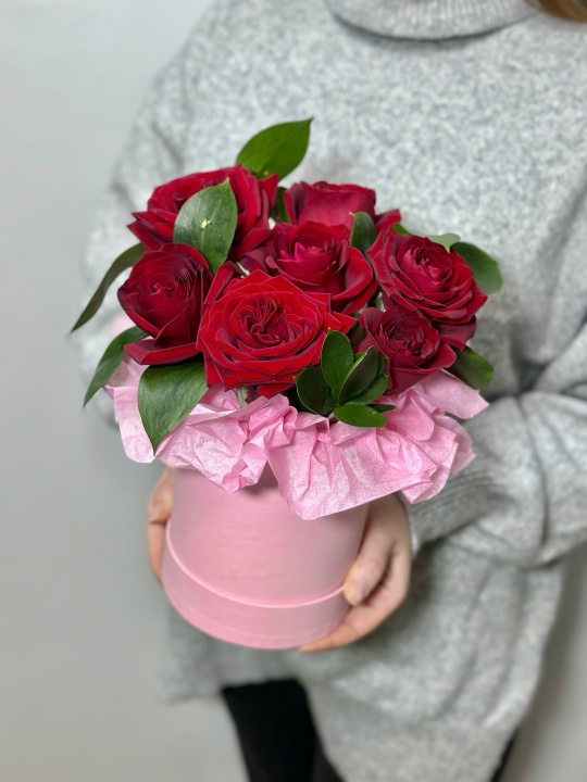 Красные розы в коробке с зеленью