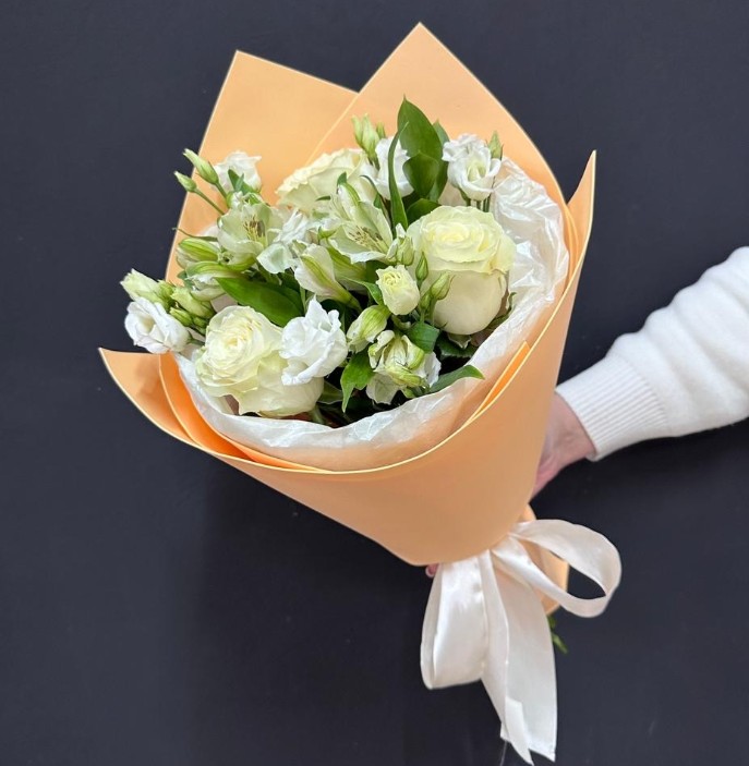 Букет в персиковой упаковке из роз, альстромерии и эустомы