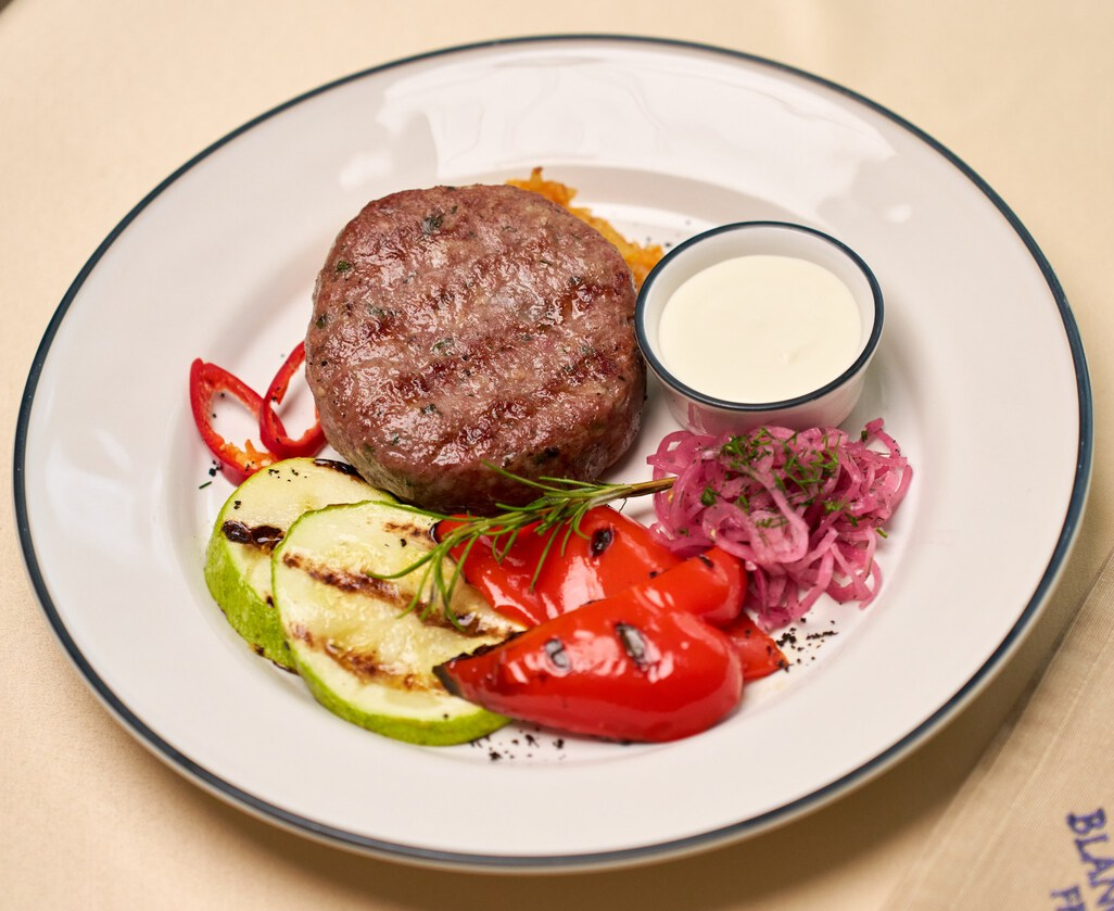 Бифштекс с тушеной капустой и овощами гриль