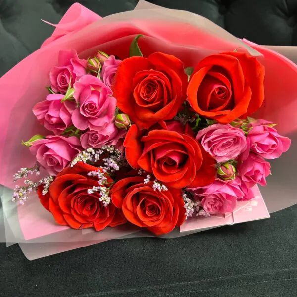 Букет из красных и малиновых роз в оформлении