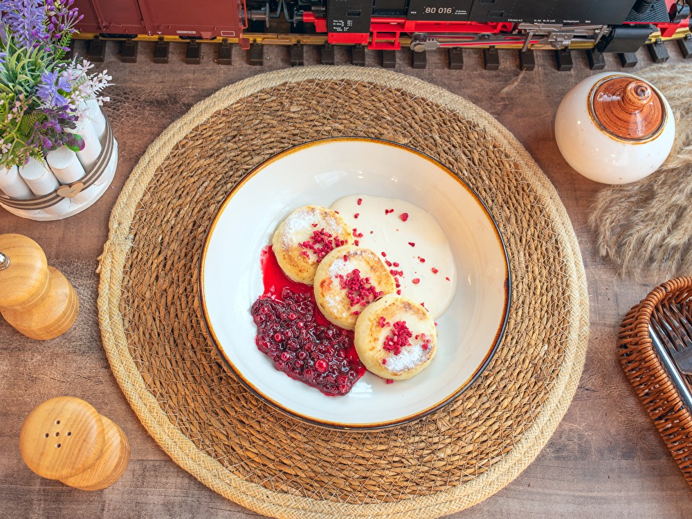 Сырники из нежного творога с кремом из сметаны и брусничным вареньем