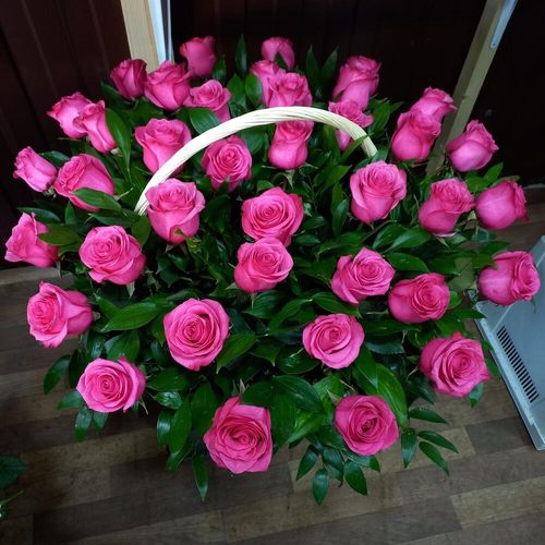 Сочные малин розы в корзине с зеленью