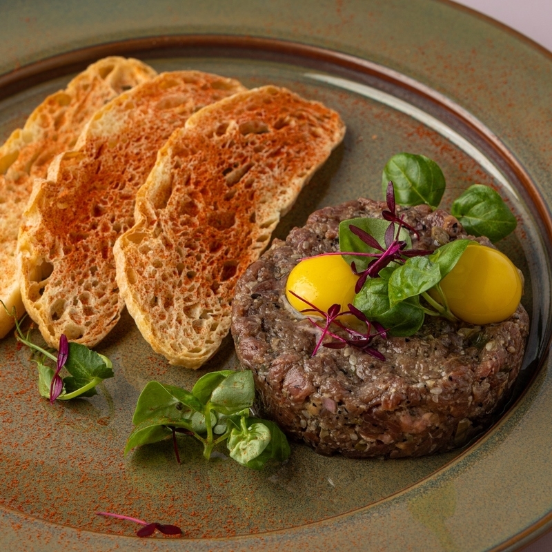 Тартар из говядины с каперсами, красным луком и перепелиным яйцом