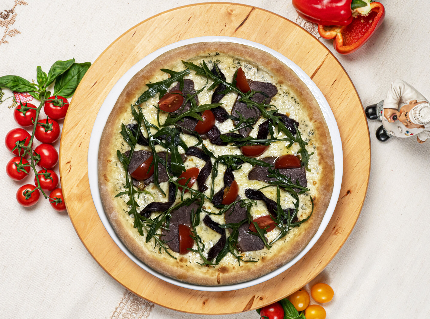 Пицца с соусом вителло тоннато, говядиной горячего и холодного копчения, черри и рукколой