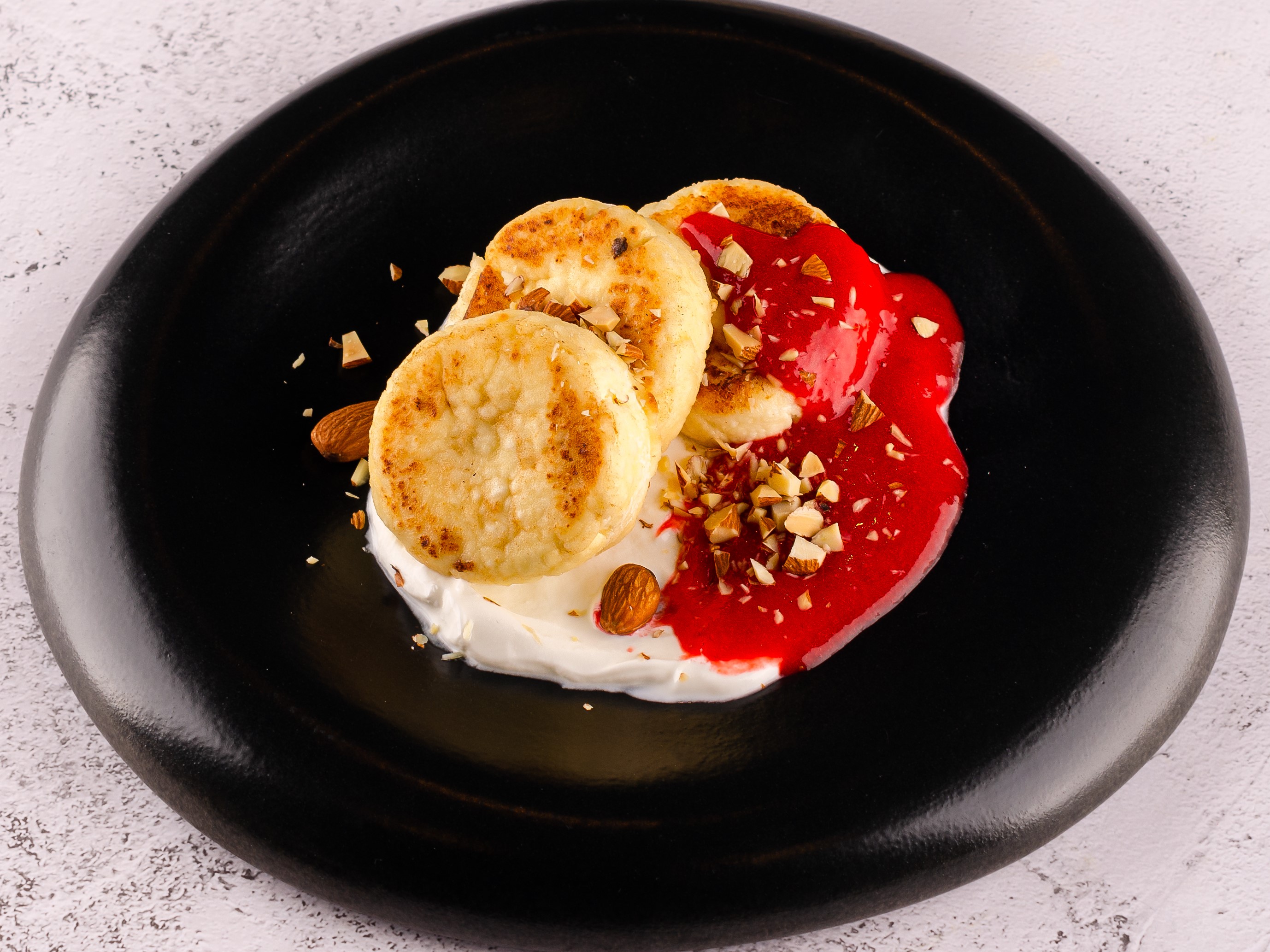 Сырники со сметаной, клубничным джемом и миндалем