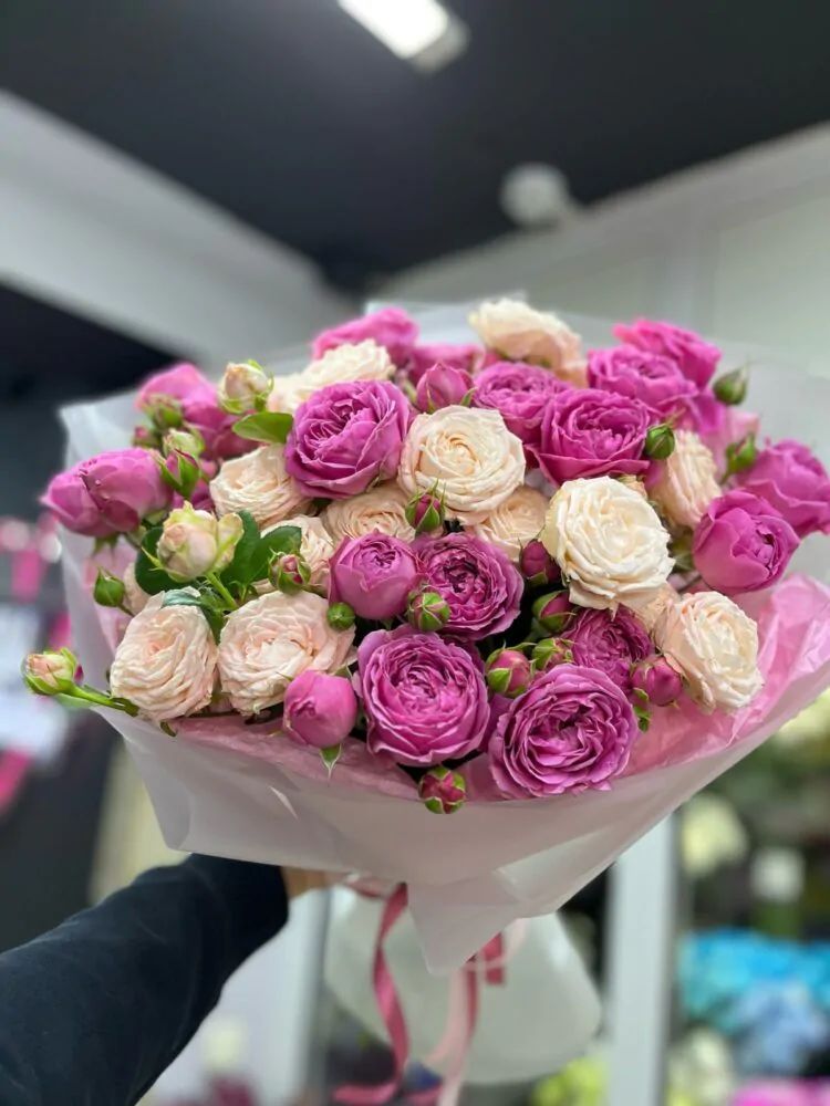 Букет из 11 персиковых и пурпурных пионовидных роз в матовом оформлении