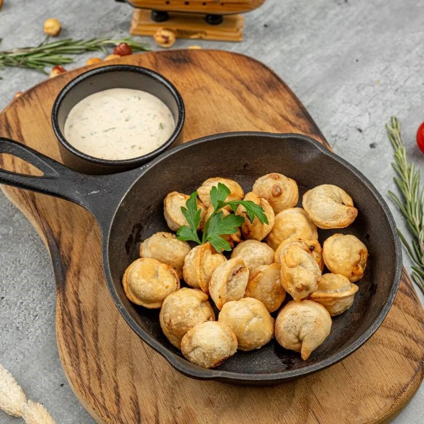 Жаренные пельмени с чесночным соусом