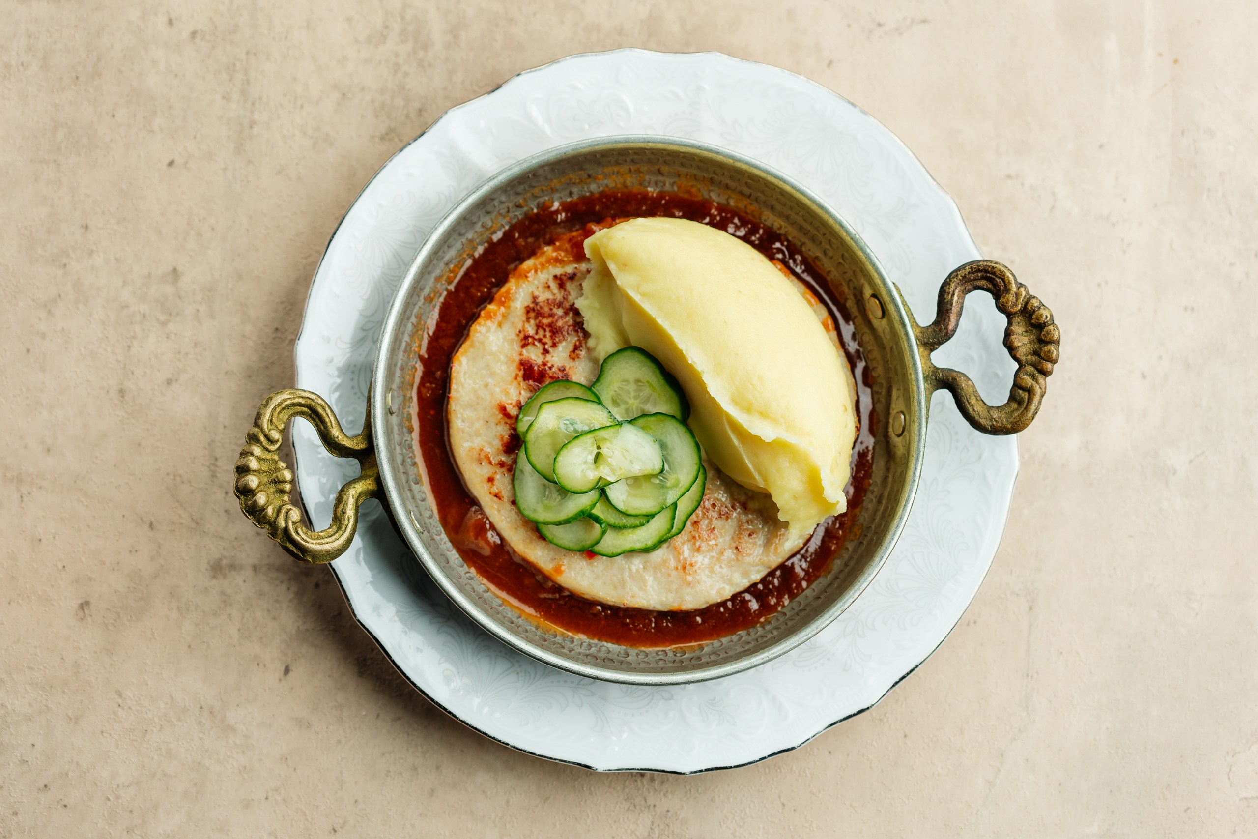 Большая куриная котлета с картофельным пюре и пряными огурцами