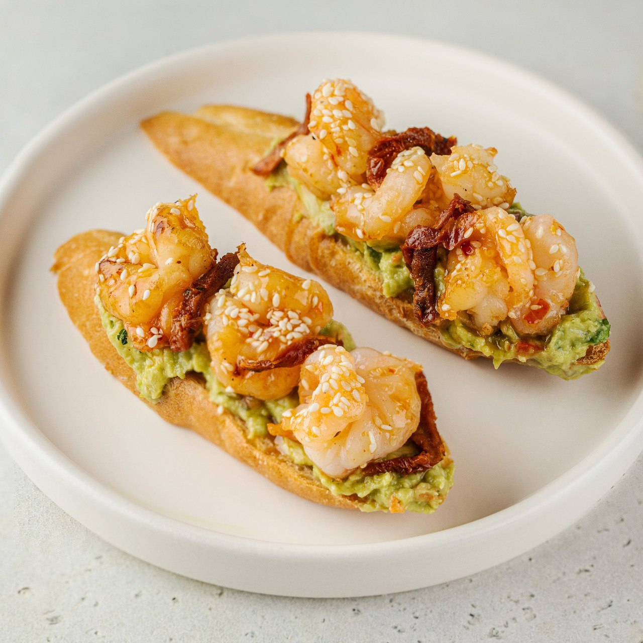 Брускетты с тигровой креветкой, гуакамоле и вялеными томатами