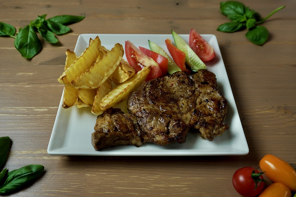 Стейк из свинины с картофелем по деревенски и свежими овощами