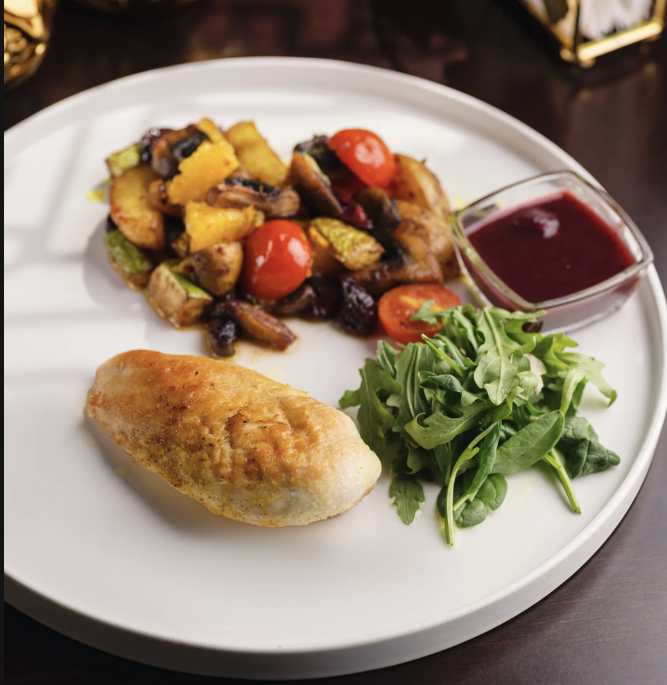 Стейк из куриного филе с овощами и клюквенным соусом